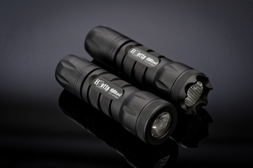 Main image for Alpha Configurator. Two Elzetta Alpha Flashlights Laying Diagonally in a Pair on Dark Background