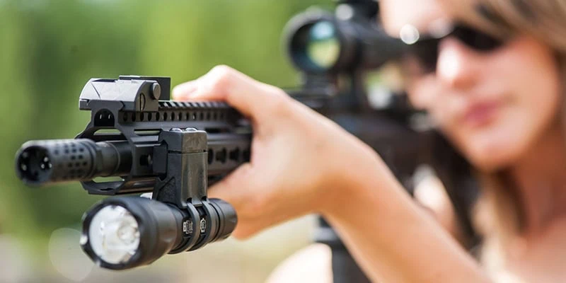woman holding rifle with zrx flashlight mount attached to it