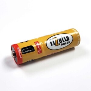 Elzetta brand rechargeable AA battery with USB Port lying on white surface.