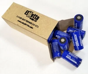 Image of cardboard box full of 12- CR123 battery cells. Box is open and several batteries can be seen at the opening. Text on Box: "Elzetta Design, CR123 Batteries (12 ct.), www.elzetta.com"
