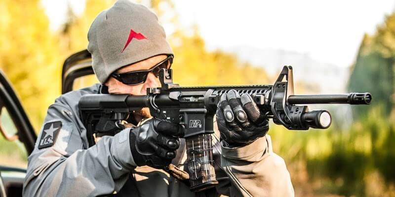 Man aiming rifle with ZFH1500 mount and Elzetta Flashlight
